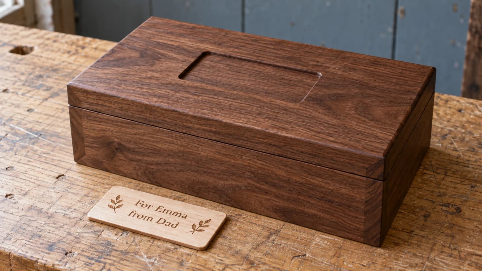 La plaque en érable « For Emma from Dad » à côté de l’encastrement correspondant dans le couvercle de la boîte en noyer