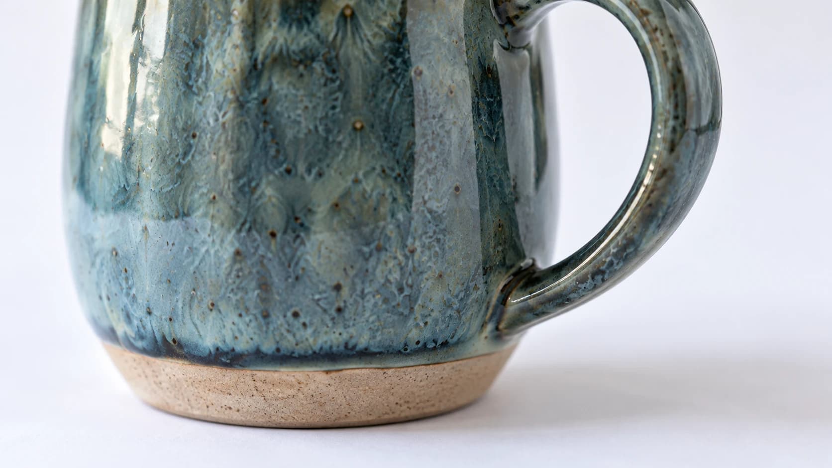 Close view of the mug glaze, handle attachment and unglazed foot
