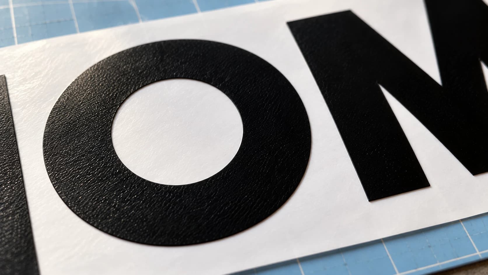 Open O counter and intact black vinyl edges on white backing