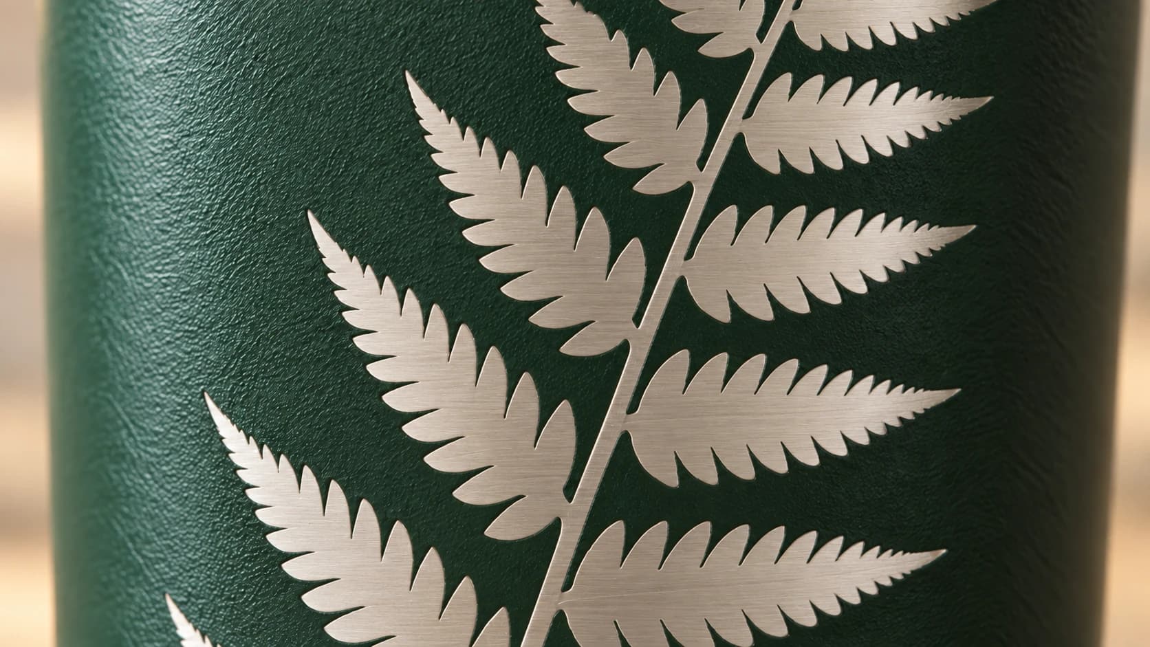 Brushed steel exposed where green tumbler coating has been removed